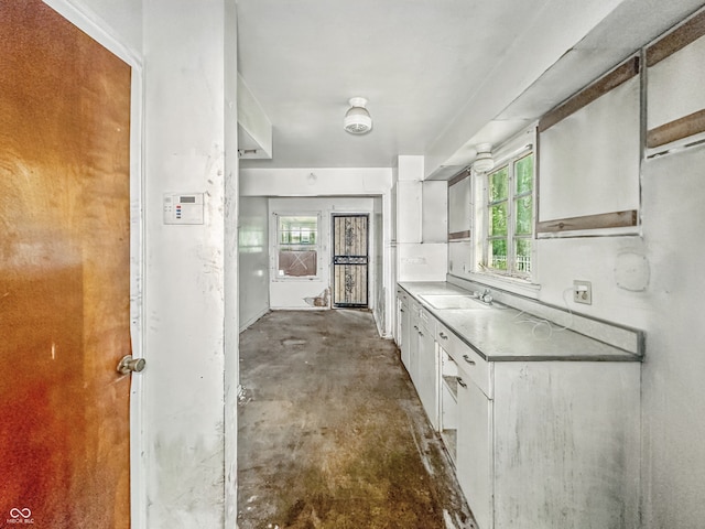 3615 N Dequincy St, Indianapolis, IN 46218 - kitchen featuring white cabinetry, a sink, unfinished concrete floors, and healthy amount of natural light