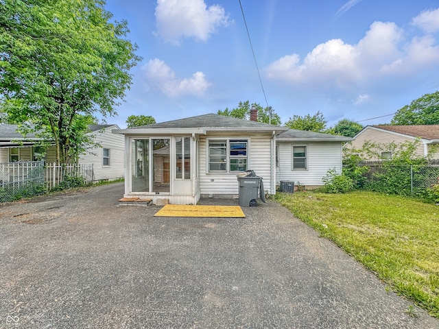3615 N Dequincy St, Indianapolis, IN 46218 - rear view of house with a chimney, a sunroom, cooling unit, and a shingled roof