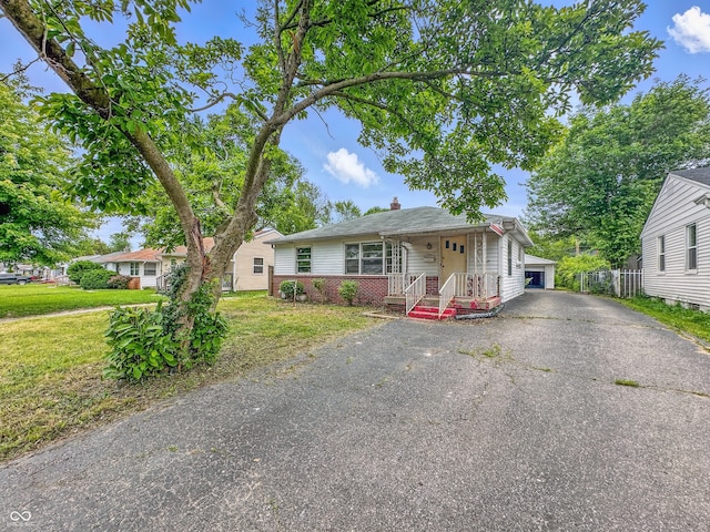 3615 N Dequincy St, Indianapolis, IN 46218 - view of front of property with a front lawn, brick siding, a chimney, and an outdoor structure