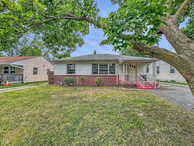 3615 N Dequincy St, Indianapolis, IN 46218 - view of front of home with brick siding, a front yard, and a chimney