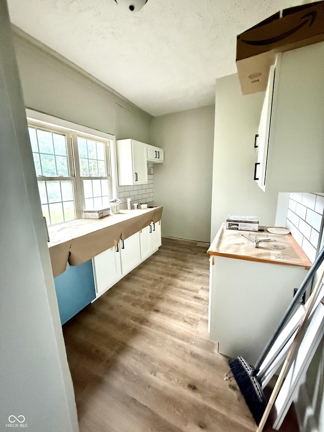 621 E Main St, Muncie, IN 47305 - kitchen with tasteful backsplash, wood finished floors, white cabinets, wooden counters, and a textured ceiling