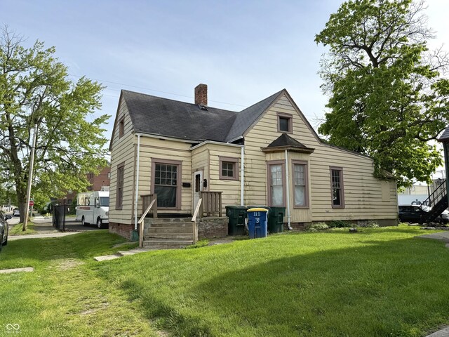 621 E Main St, Muncie, IN 47305 - back of house featuring a chimney, a lawn, and a shingled roof