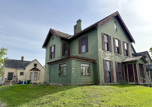 621 E Main St, Muncie, IN 47305 - rear view of house featuring a chimney, a lawn, and stucco siding