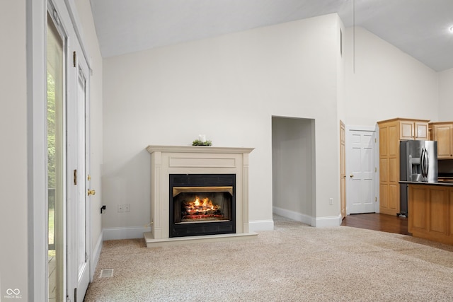 435 Cedar View Ln, Bedford, IN 47421 - unfurnished living room featuring carpet, baseboards, high vaulted ceiling, and a lit fireplace