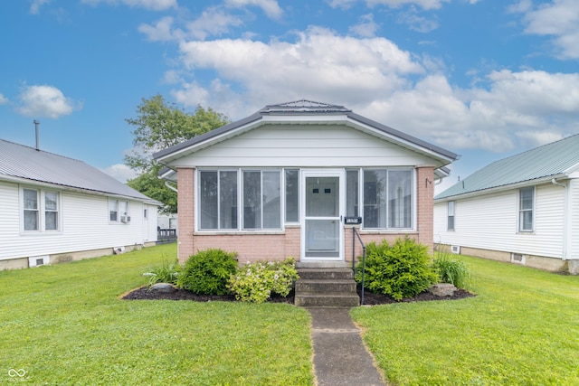 1310 N Cherry St, Rushville, IN 46173 - view of front of property featuring brick siding, a front yard, and a sunroom