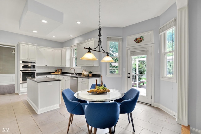1410 Shadow Ct, Zionsville, IN 46077 - kitchen featuring appliances with stainless steel finishes, a kitchen island, dark countertops, decorative backsplash, and white cabinetry
