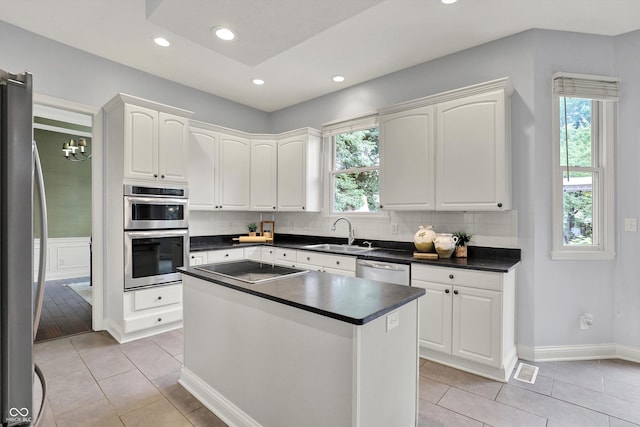 1410 Shadow Ct, Zionsville, IN 46077 - kitchen featuring stainless steel appliances, dark countertops, backsplash, white cabinetry, and recessed lighting