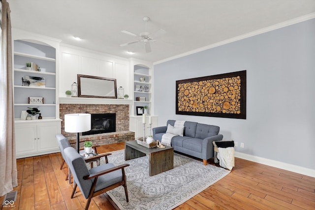1410 Shadow Ct, Zionsville, IN 46077 - living area featuring light wood-style floors, crown molding, a ceiling fan, a fireplace, and built in shelves