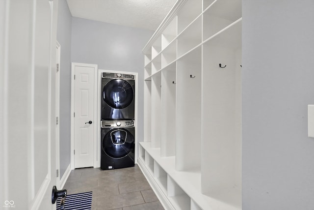 1410 Shadow Ct, Zionsville, IN 46077 - laundry room featuring stacked washing machine and dryer, tile patterned flooring, and a textured ceiling