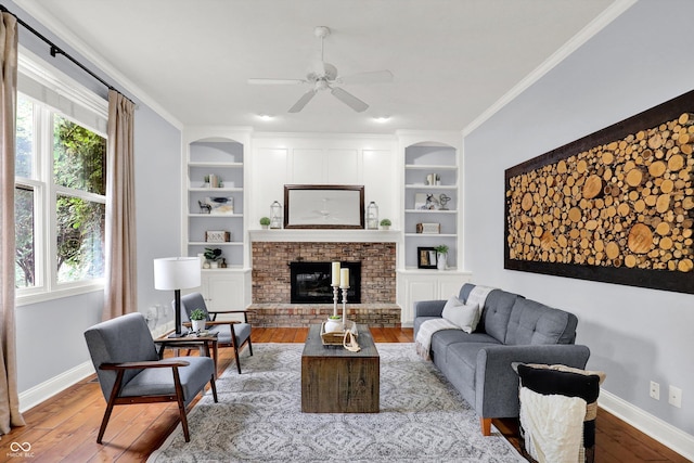 1410 Shadow Ct, Zionsville, IN 46077 - living area with wood-type flooring, ceiling fan, built in shelves, a brick fireplace, and ornamental molding