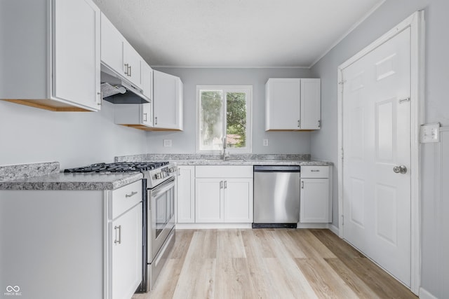 903 Sunset Dr, Lebanon, IN 46052 - kitchen featuring stainless steel appliances, under cabinet range hood, light wood-type flooring, white cabinets, and a sink