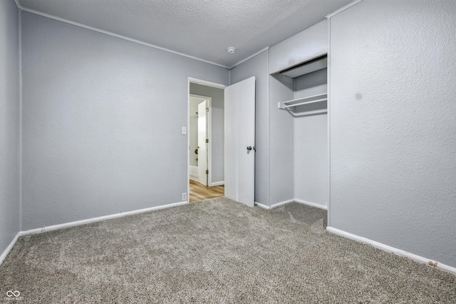 903 Sunset Dr, Lebanon, IN 46052 - unfurnished bedroom with carpet flooring, a textured ceiling, baseboards, a textured wall, and a closet