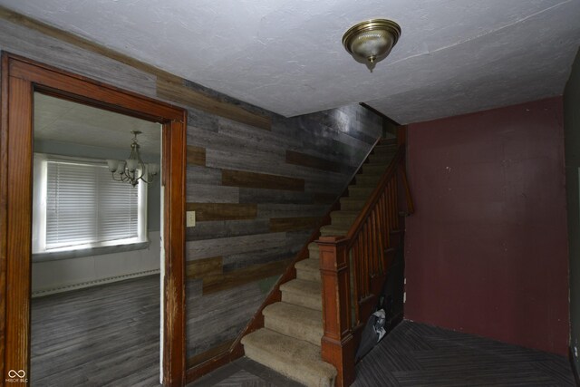 364 S Cole St, Indianapolis, IN 46241 - stairway featuring a baseboard heating unit, wood walls, a chandelier, and wood finished floors