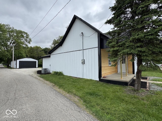 317 W Pierson St, Greenfield, IN 46140 - view of side of home with a garage, an outdoor structure, a yard, and central AC unit
