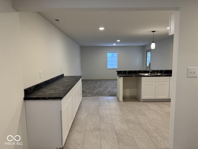 317 W Pierson St, Greenfield, IN 46140 - kitchen with a sink, white cabinetry, light colored carpet, recessed lighting, and dark stone countertops
