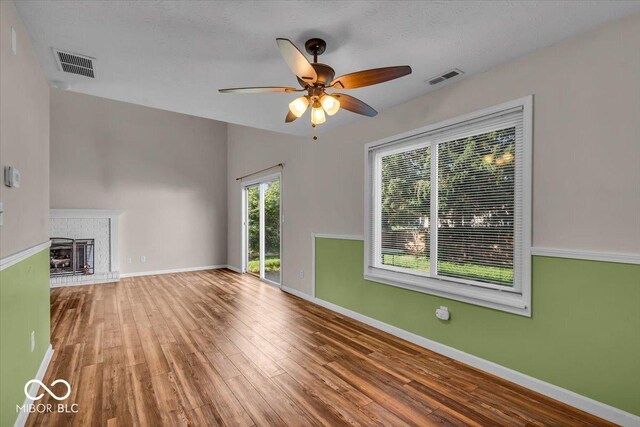 8908 Sunningdale Blvd, Indianapolis, IN 46234 - unfurnished living room featuring wood finished floors, a ceiling fan, and a brick fireplace