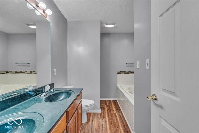 8908 Sunningdale Blvd, Indianapolis, IN 46234 - full bath with wood finished floors, a garden tub, double vanity, and a textured ceiling