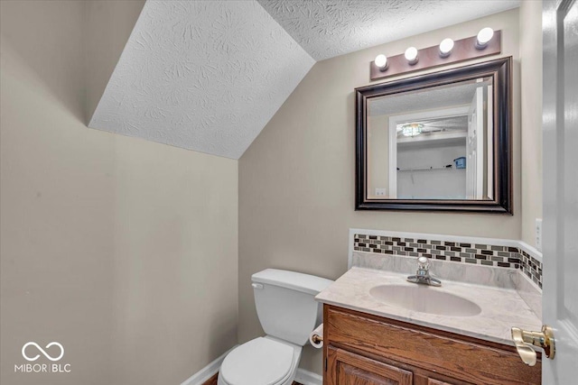 8908 Sunningdale Blvd, Indianapolis, IN 46234 - bathroom featuring a textured ceiling, vaulted ceiling, vanity, and decorative backsplash