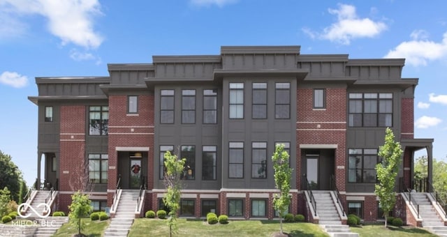 420 Monon Wy Dr, Carmel, IN 46032 - townhome / multi-family property featuring stairway, board and batten siding, brick siding, and a front yard