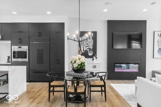 420 Monon Wy Dr, Carmel, IN 46032 - dining area featuring light wood-type flooring, recessed lighting, and a glass covered fireplace