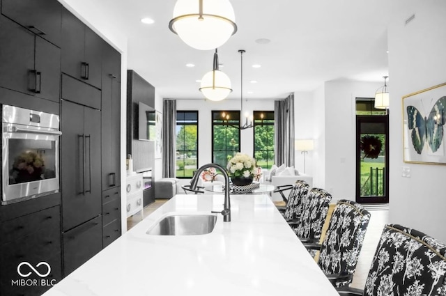 420 Monon Wy Dr, Carmel, IN 46032 - kitchen with oven, a sink, light countertops, open floor plan, and pendant lighting