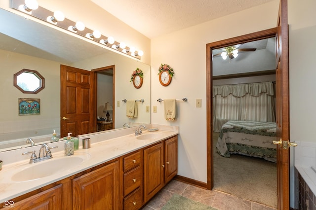 1607 Michelle Mnr, Danville, IN 46122 - ensuite bathroom with double vanity, a bathtub, ceiling fan, baseboards, and a textured ceiling