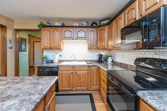 1607 Michelle Mnr, Danville, IN 46122 - kitchen featuring black appliances, a sink, light wood-type flooring, backsplash, and a textured ceiling