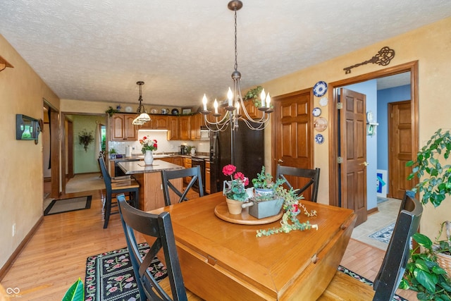 1607 Michelle Mnr, Danville, IN 46122 - dining space with a chandelier, light wood-style flooring, a textured ceiling, and baseboards