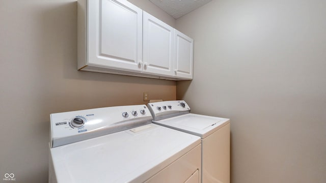3959 Towhees Dr, Indianapolis, IN 46237 - laundry room with washer and clothes dryer, cabinet space, and a textured ceiling