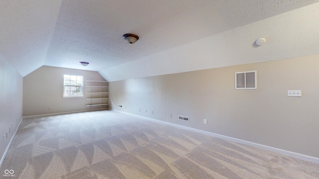 3959 Towhees Dr, Indianapolis, IN 46237 - additional living space with lofted ceiling, a textured ceiling, light carpet, and baseboards