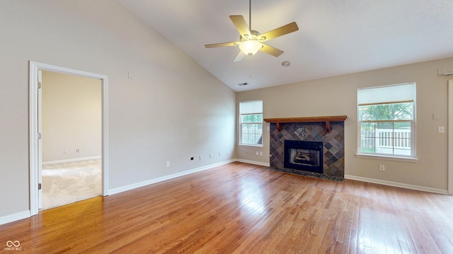3959 Towhees Dr, Indianapolis, IN 46237 - unfurnished living room featuring light wood finished floors, a ceiling fan, baseboards, high vaulted ceiling, and a tiled fireplace