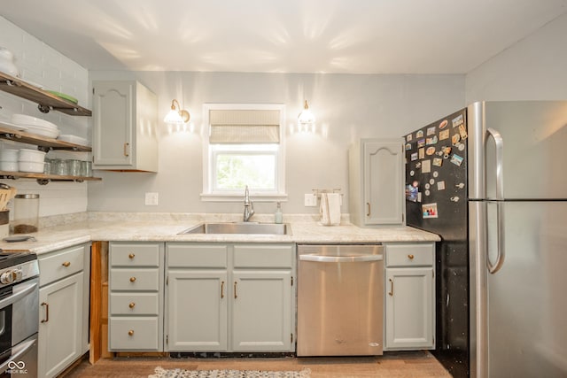 311 Northshore Blvd, Anderson, IN 46011 - kitchen featuring stainless steel appliances, a sink, open shelves, and light wood-style flooring