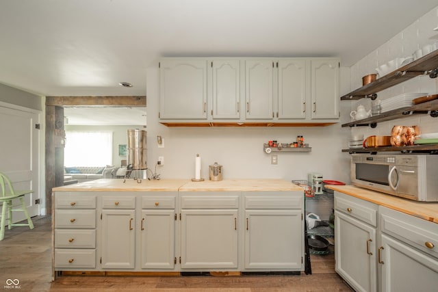 311 Northshore Blvd, Anderson, IN 46011 - kitchen with stainless steel microwave, open shelves, light wood finished floors, and light countertops