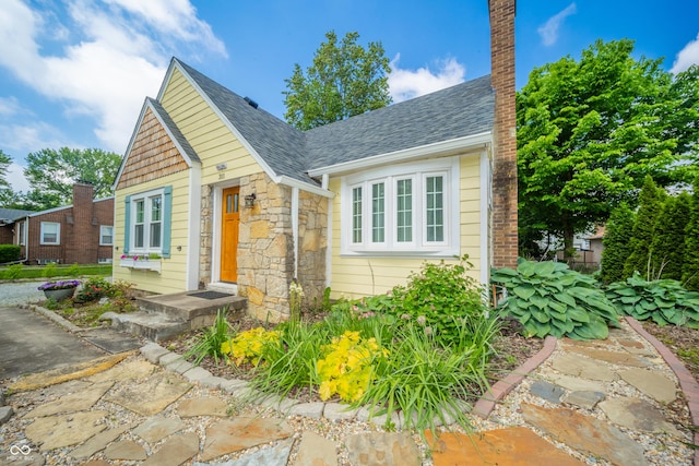 311 Northshore Blvd, Anderson, IN 46011 - view of front facade featuring stone siding, a chimney, and roof with shingles