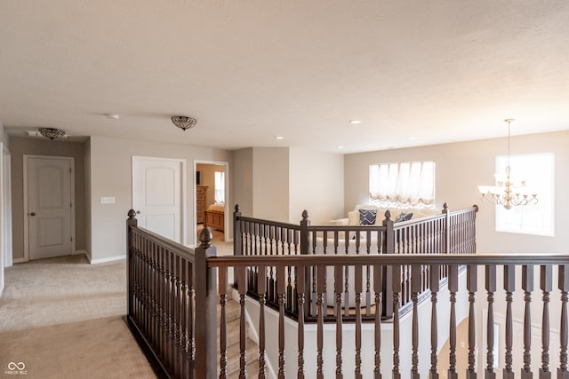 1661 Devonshire Ave, Avon, IN 46123 - hall with an upstairs landing, light carpet, a chandelier, and baseboards