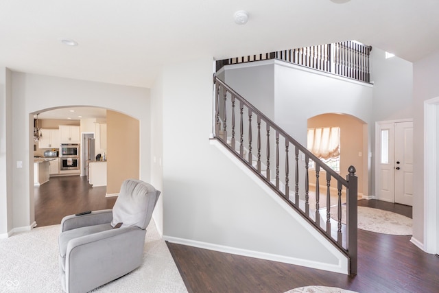 1661 Devonshire Ave, Avon, IN 46123 - staircase featuring arched walkways, wood finished floors, baseboards, a high ceiling, and recessed lighting