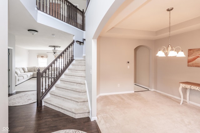 1661 Devonshire Ave, Avon, IN 46123 - staircase featuring arched walkways, baseboards, a chandelier, carpet, and a tray ceiling