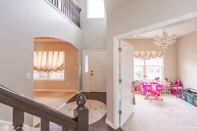 1661 Devonshire Ave, Avon, IN 46123 - carpeted entrance foyer with arched walkways, a chandelier, plenty of natural light, a high ceiling, and baseboards