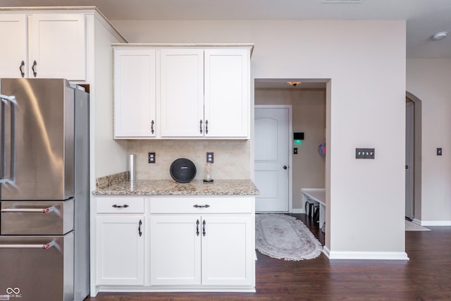 1661 Devonshire Ave, Avon, IN 46123 - kitchen with freestanding refrigerator, arched walkways, baseboards, dark wood-style flooring, and white cabinetry