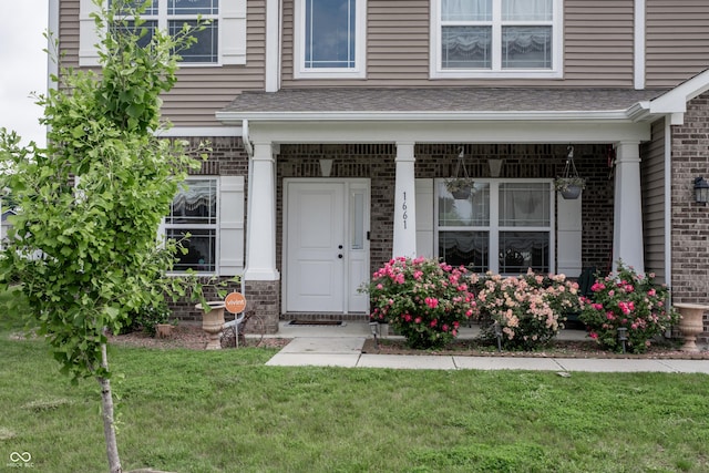 1661 Devonshire Ave, Avon, IN 46123 - view of exterior entry featuring brick siding, a yard, and a porch