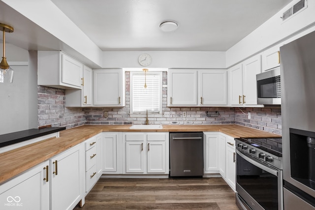2263 Rome Dr, Indianapolis, IN 46228 - kitchen with butcher block countertops, stainless steel appliances, a sink, and white cabinets
