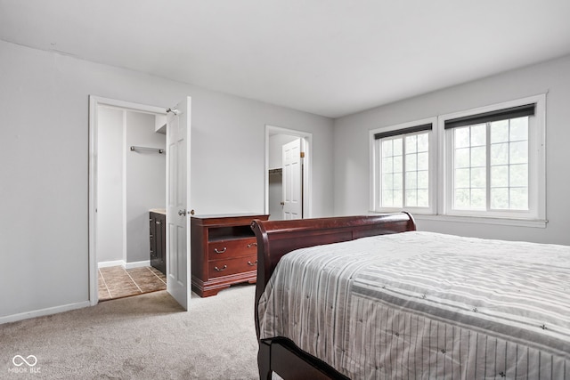 2263 Rome Dr, Indianapolis, IN 46228 - carpeted bedroom with baseboards, ensuite bath, and a walk in closet