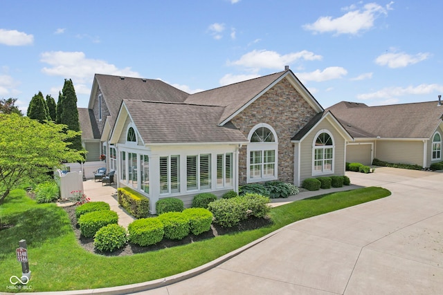 1146 Distinctive Way, Greenfield, IN 46140 - view of front of house featuring stone siding, driveway, an attached garage, and roof with shingles