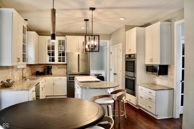 6862 Riverside Way, Fishers, IN 46038 - kitchen featuring appliances with stainless steel finishes, a sink, a center island, dark wood-type flooring, and backsplash
