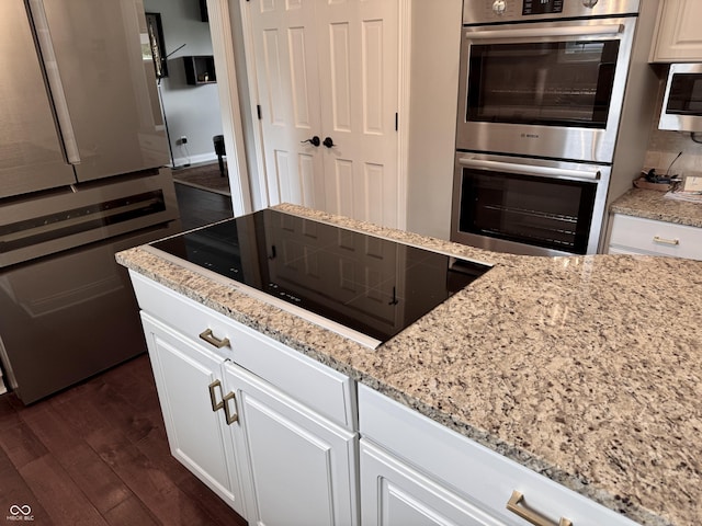 6862 Riverside Way, Fishers, IN 46038 - kitchen featuring appliances with stainless steel finishes, dark wood finished floors, light stone counters, and white cabinetry