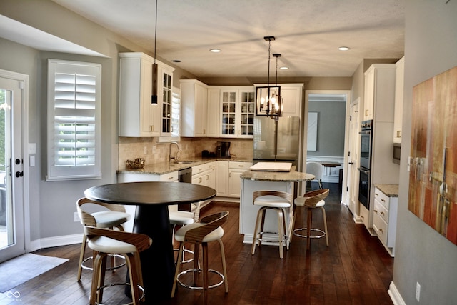 6862 Riverside Way, Fishers, IN 46038 - kitchen featuring appliances with stainless steel finishes, a kitchen island, dark wood-style flooring, glass insert cabinets, and backsplash
