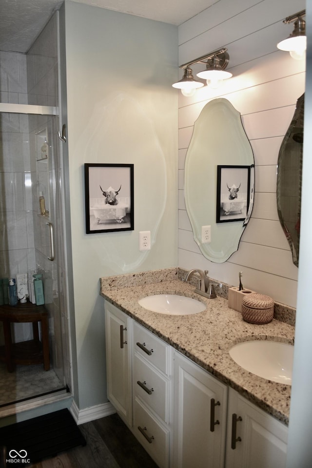 6862 Riverside Way, Fishers, IN 46038 - bathroom featuring double vanity, a shower stall, wood finished floors, and baseboards