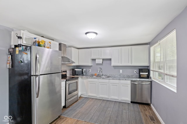 938 N Tuxedo St, Indianapolis, IN 46201 - kitchen with appliances with stainless steel finishes, a sink, light wood-style flooring, and white cabinetry