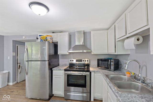 938 N Tuxedo St, Indianapolis, IN 46201 - kitchen featuring wall chimney exhaust hood, stainless steel appliances, a sink, white cabinetry, and light countertops