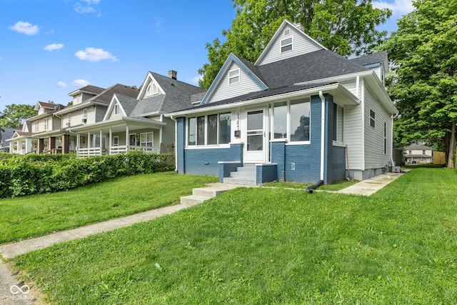 938 N Tuxedo St, Indianapolis, IN 46201 - bungalow-style house with a front yard, roof with shingles, entry steps, brick siding, and central AC unit